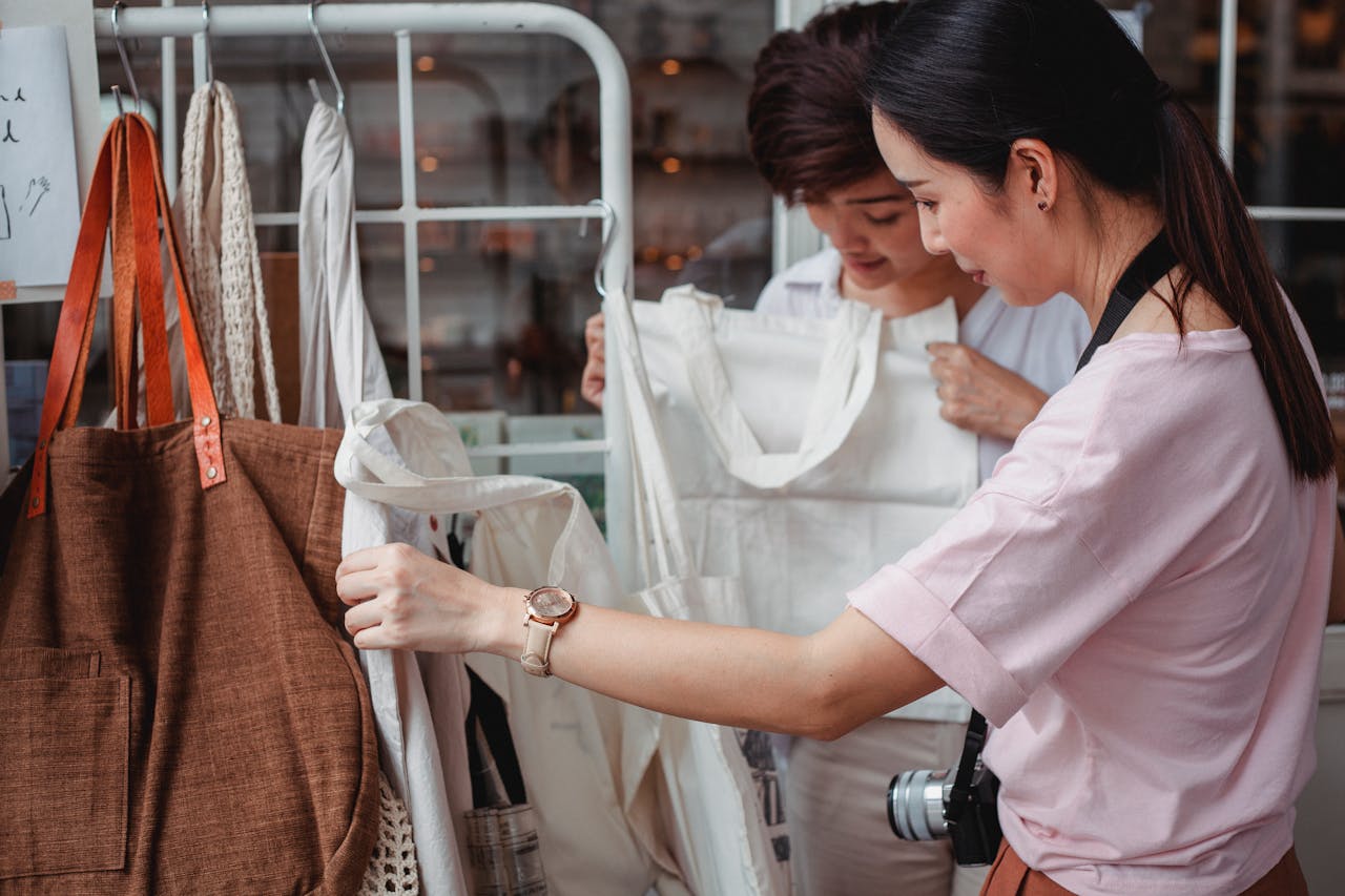 hero-gallery-01 Two women examining eco-friendly bags in a fashionable boutique setting, highlighting sustainable shopping.